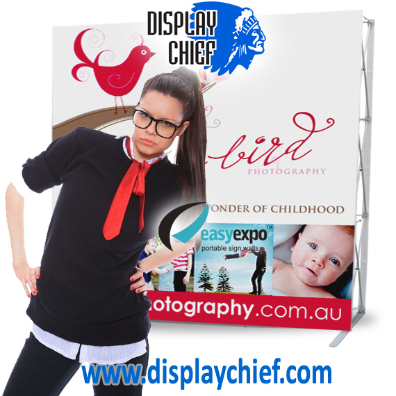 Woman looking at camera, Creative displays come alive with your brand and logos printed on a pop up banner stand display unit like these.